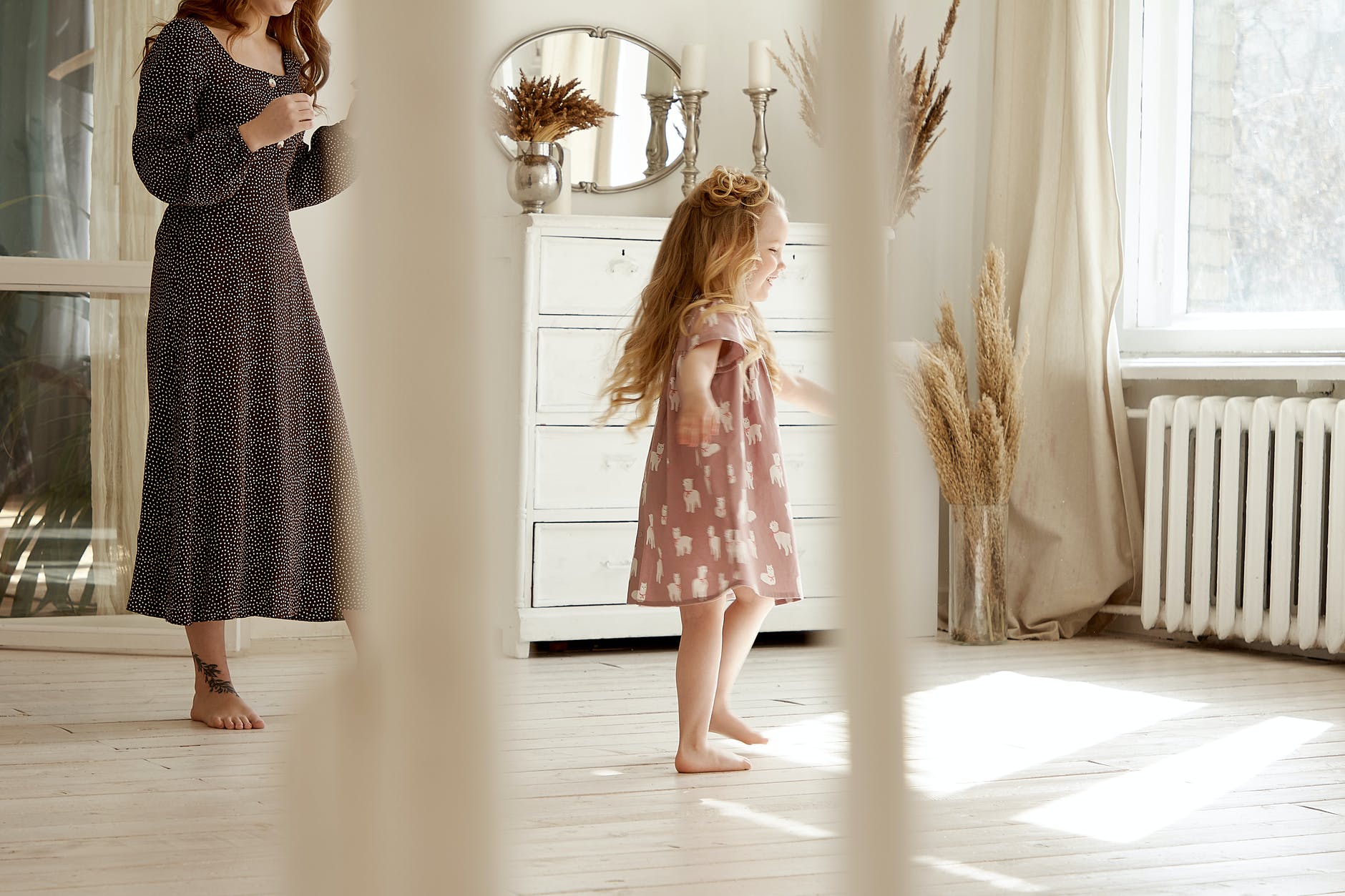 woman walking behind toddler