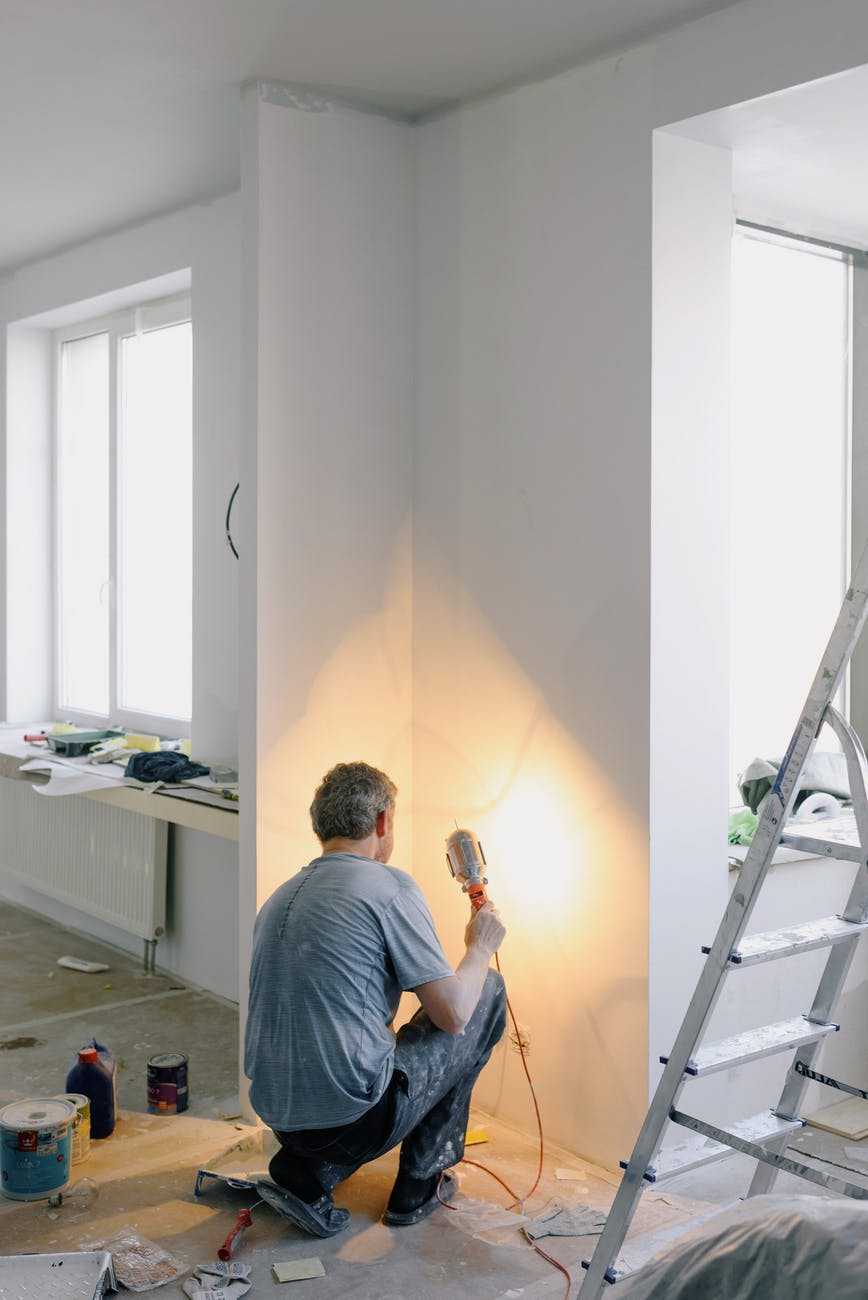 faceless man working with lamp in room