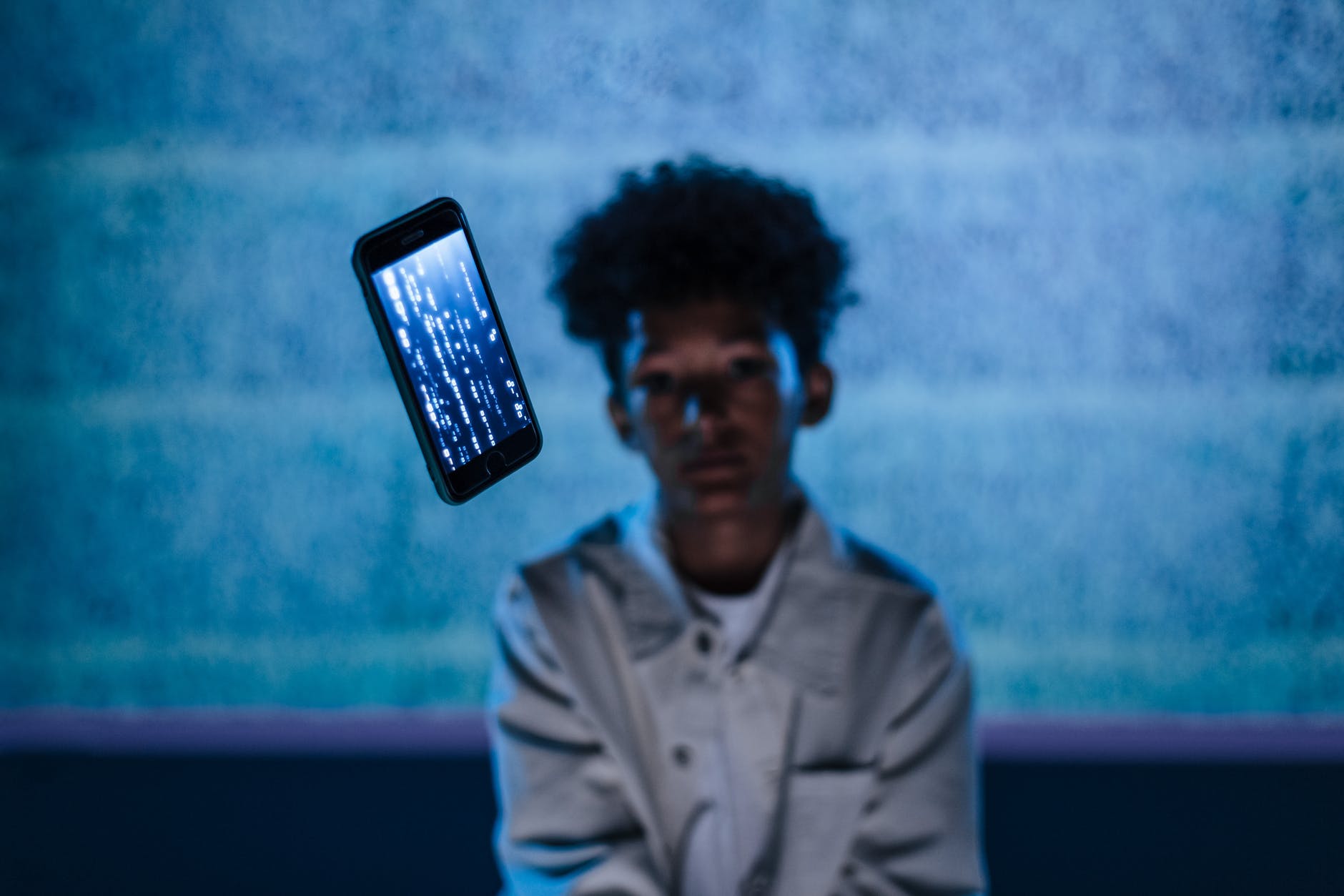 mobile phone hanging in front of a boy