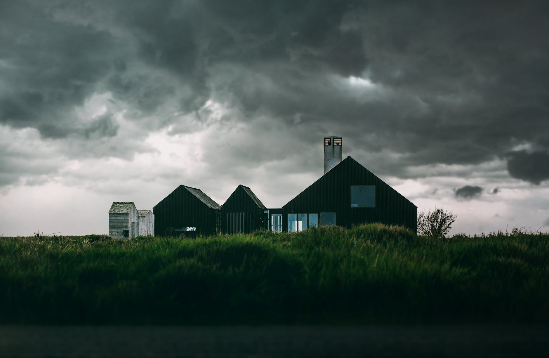 black and white house under thick clouds