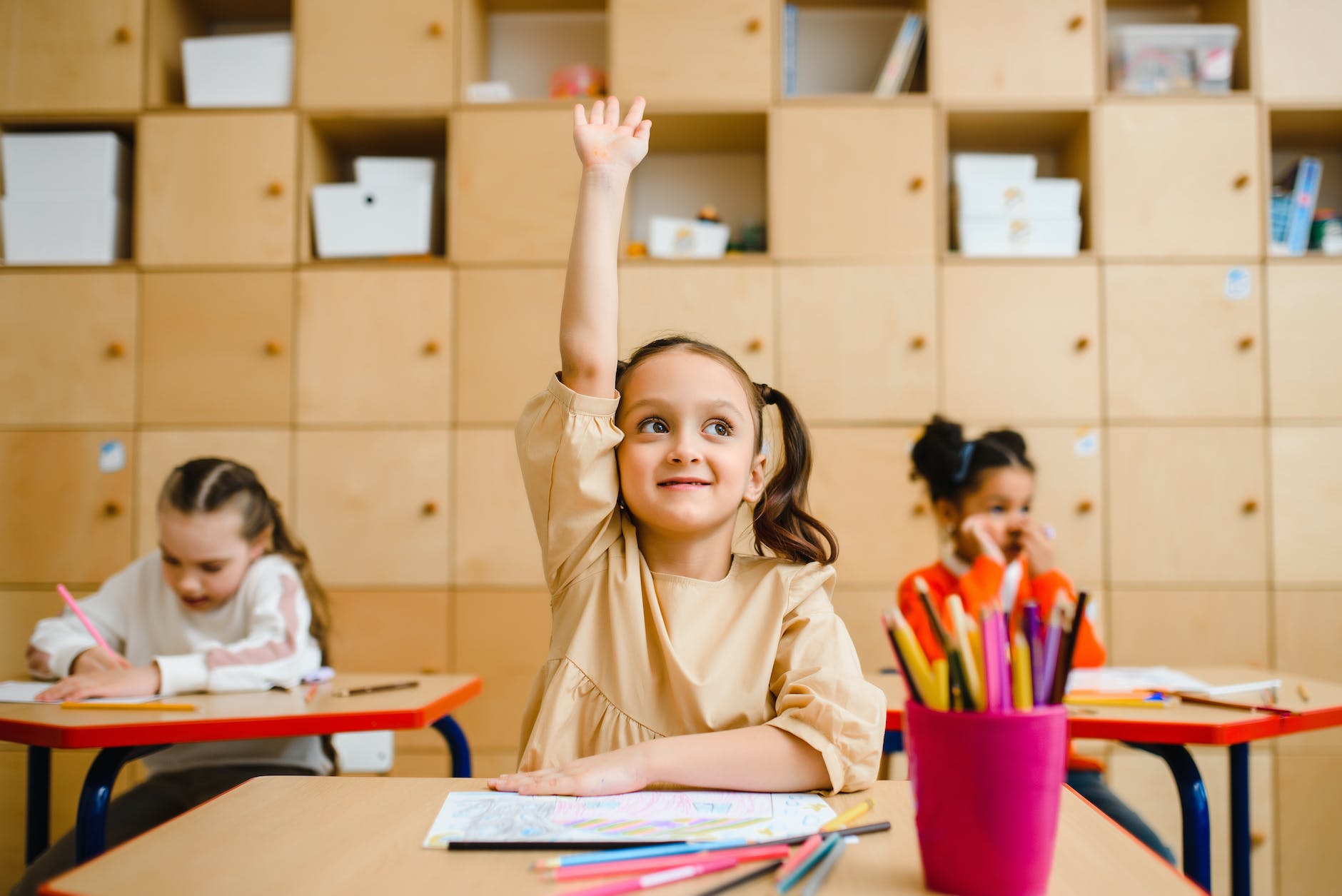 girl raising hand inside the classroom