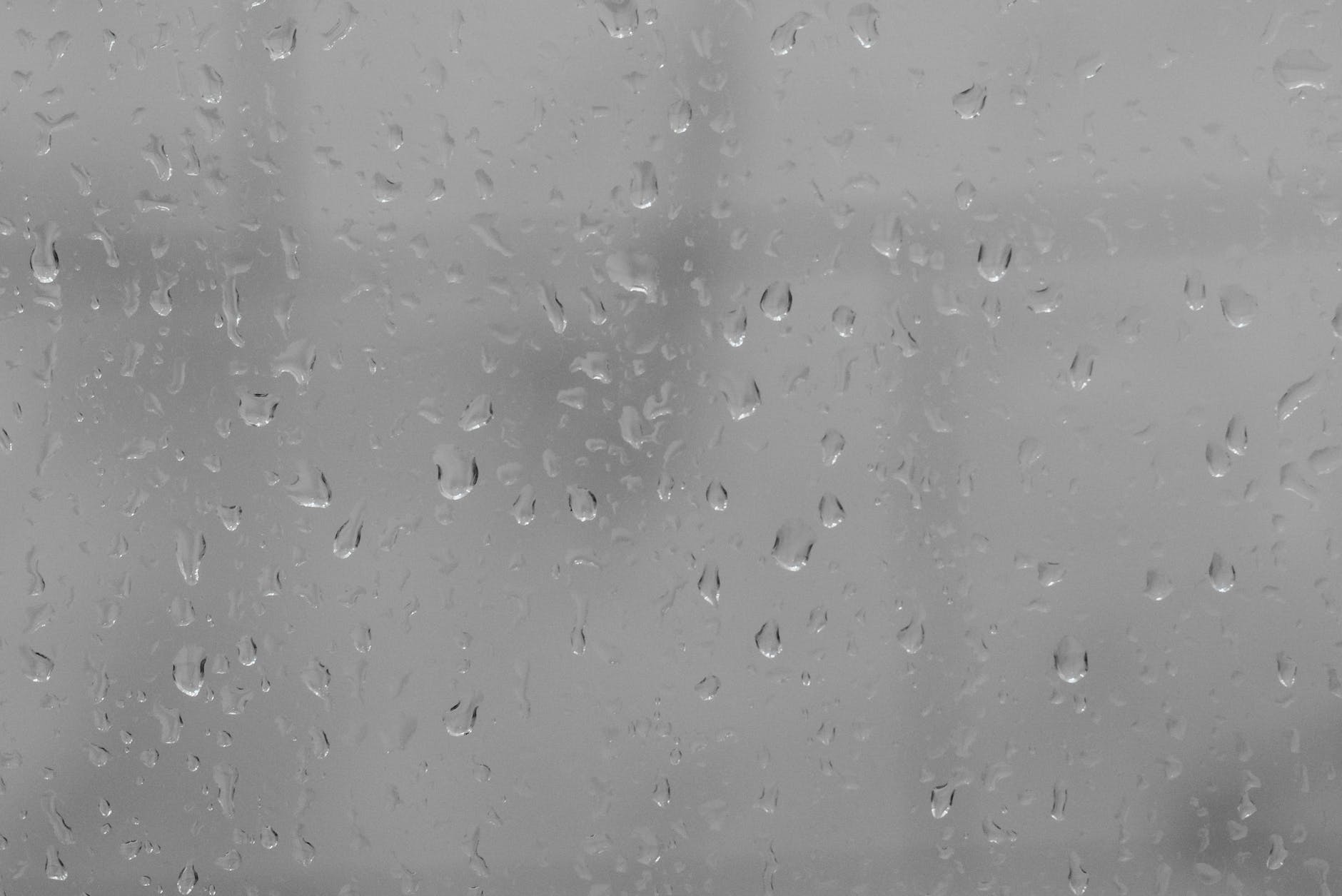 window glass covered with raindrops on cloudy day