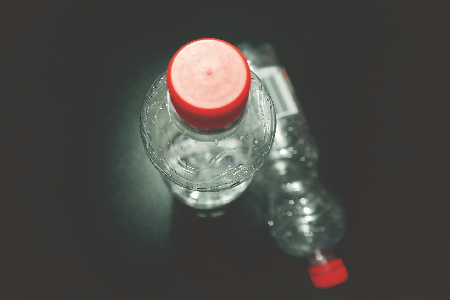 two clear plastic bottles on black surface